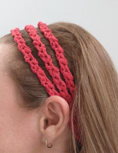 a close up of a woman wearing a red crochet headband