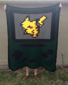 a person holding up a blanket made to look like a pikachu