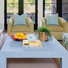 a living room with two couches and a coffee table in front of large windows