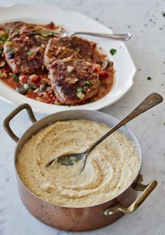 two pans filled with food sitting on top of a white marble counter next to each other