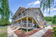 an apartment building with stairs leading up to the upper level and second story balconys