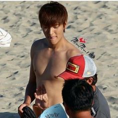 a shirtless man holding a frisbee on the beach