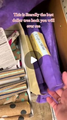 someone is opening up some fabric rolls in a box