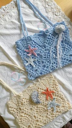 three crocheted purses sitting on top of a white doily covered table