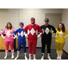 four people dressed up in costumes standing next to each other with their hands on hipss