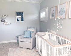 a baby's room with a chair, crib and pictures on the wall