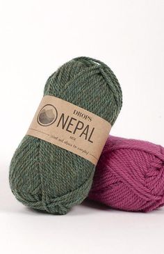 two skeins of green and pink yarn are next to each other on a white background