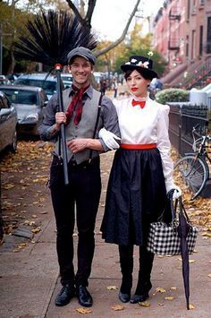 two people dressed in costumes standing on a sidewalk