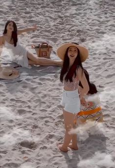 two women on the beach in hats and bathing suits