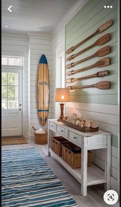 a living room filled with furniture and a surfboard mounted to the side of a wall