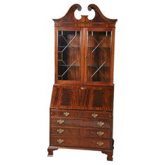 an antique wooden cabinet with glass doors