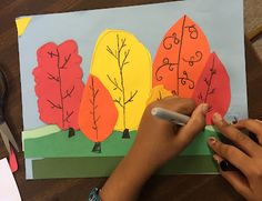 someone is making a paper cutout of trees