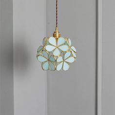 a light fixture hanging from the side of a door with glass flowers on it's sides