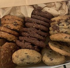 a box filled with lots of different types of cookies and muffins on top of each other