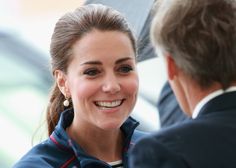 the duke and duchess smile as they talk to each other in front of an umbrella