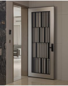 an open door with black and white bars on the glass is in front of a marble wall