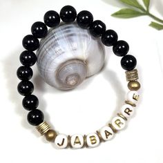 "Black Beaded Name Bracelet, Personalized Jewelry, Friendship Gift, Kids Jewellery, Custom Name Bracelet, Alphabet Bracelet, Word Bracelet ----- Black, gold and white beaded elastic name bracelet can be customized with your word, name, and size. Made with 8mm black glass beads alongside gold wood and brass heishi beads, the style is perfect for adults and kids alike! Great for stacking, or wearing in groups like birthday parties for easy identification! INCLUDES: 🌸 One black, gold and white nam Bracelet Alphabet, Alphabet Bracelet, Bracelet Word, Beaded Name Bracelet, Kids Jewellery, Jewelry Friendship, Word Bracelet, Letter Beads, Bracelet Black