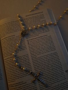 an open book with a rosary on it