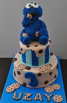 a blue and white birthday cake with cookie monster on top