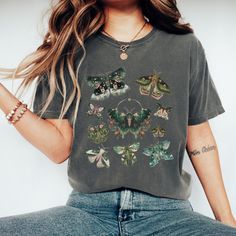 Embrace nature's beauty with our Cottagecore-inspired Moth T-shirt! Featuring an elegant moth design, this tee captures the whimsical charm of the countryside. Perfect for lovers of nature and vintage aesthetics, it's a soft and stylish addition to your wardrobe, ideal for peaceful days spent outdoors or cozying up at home. Still not the right shirt for you? You can find more cottagecore shirts here: https://www.etsy.com/shop/DreamyDesignsByTia?ref=seller-platform-mcnav&section_id=50988949 You c Nature-inspired Crew Neck Top With Plant Print, Nature-inspired Top With Plant Print And Crew Neck, Botanical Graphic Print Green Tops, Green Botanical Graphic Print Tops, Nature-inspired Cotton Top With Plant Print, Nature-inspired Cotton Tops With Graphic Print, Spring Nature-inspired Tops With Graphic Print, Nature-inspired Relaxed Fit Short Sleeve Tops, Nature-inspired Graphic Print Crew Neck Top