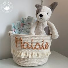 a stuffed animal sitting in a basket with the word mom on it's side