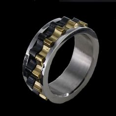 a gold and black ring with two tone rings on the inside, in front of a black background