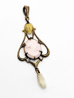 Gold Diggers Black Hills gold Pink cameo freshwater pearl gold filled pendant. This stunning antique piece of Black Hills Gold jewelry was created by Gold Diggers. Black Hills gold has several different designers that work using the specific leaf elements that BHG has been known for creating. This beautiful gold filled pendant has a yellow gold leaf accent above a prong set pink cameo with a freshwater pearl drop. Stamped with the unique W symbol that Gold Diggers uses on the back of the bail. F Vintage Pearl Pendant Medallion Jewelry, Antique Gold Cameo Pendant Necklace, Elegant Bronze Cameo Jewelry, Vintage Oval Pearl Pendant Jewelry, Antique Oval Pearl Pendant Jewelry, Oval Cameo Pendant In Brass, Vintage Pearl Pendant Jewelry, Cameo Brass Oval Pendant Jewelry, Oval Cameo Pendant Jewelry In Brass