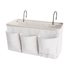 three pockets hanging on the side of a white storage bag with black handles and hooks