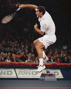 a man jumping in the air with a tennis racket