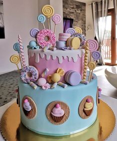 a colorful cake decorated with candies, lollipops and donuts on top