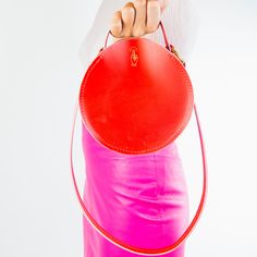 Circular leather handbag. Leather Bucket Bag With Round Handle For On-the-go, Leather Shoulder Bag With Round Handle For On-the-go, Red Bag With Round Handle For Everyday Use, Modern Bags With Round Handle And Leather Lining, Modern Bags With Leather Lining And Round Handle, Modern Bag With Round Handle And Leather Lining, Red Shoulder Bag With Round Handle For Daily Use, Round Case Bag With Detachable Handle, Red Shoulder Bag With Detachable Round Handle