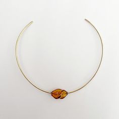 A hammered brass choker featuring a small amber glass bead    made in california and murano italy    material: glass brass Brass Choker, Murano Italy, Hammered Brass, Jewelry Design Necklace, Amber Jewelry, Amber Glass, How To Make Beads, Glass Bead, Womens Jewelry Necklace