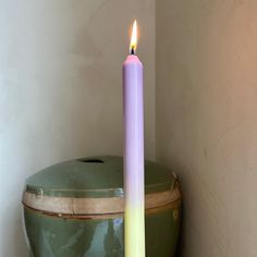 a lit candle sitting on top of a green container