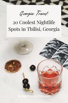 a table topped with an alcoholic drink and two pictures