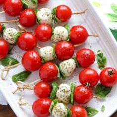 tomatoes and mozzarella skewers on a white tray ready to be eaten