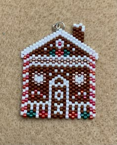 a brown and white beaded ornament with a house on it's side