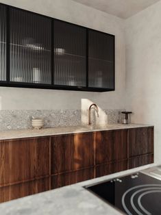 a kitchen with marble counter tops and wooden cabinets