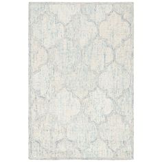 a white rug with blue and grey designs on the bottom, in an area that looks like it has been made out of fabric