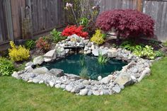 a small pond surrounded by rocks and flowers