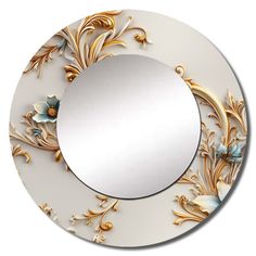 a round mirror with flowers and leaves painted on the side, in gold and white