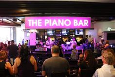 a group of people sitting in front of a piano bar