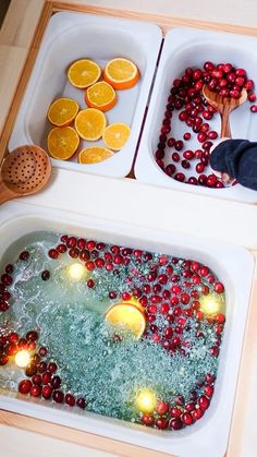 two bowls filled with oranges and cranberries on top of a table