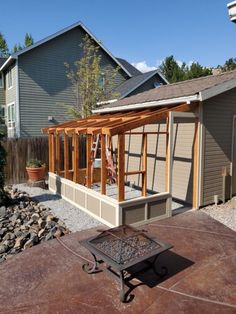 a backyard area with a fire pit, patio and building in the backround