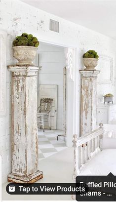 an old white bedroom with two planters on the top of each column and one in front of the mirror