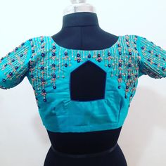 a blue blouse on a mannequin with beadings and sequins