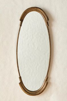 an oval mirror hanging on the wall