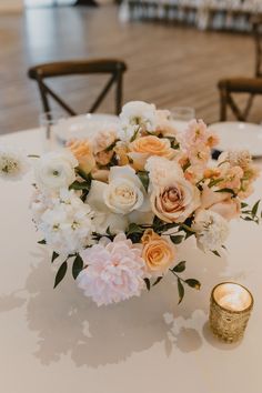 a vase filled with flowers sitting on top of a table next to a lit candle