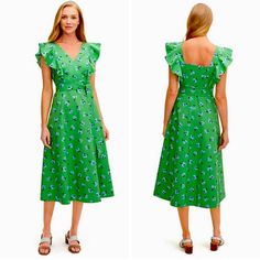 a woman is wearing a green dress with flowers on it and the back of her dress has ruffles