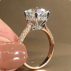 a person holding a diamond ring in their hand