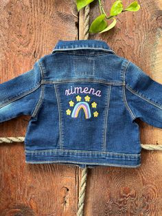 Personalized Baby/Toddler/Kids unisex  trucker denim jackets with name or word of choice.  We provide two brand options Levi's or Old Navy jackets (price difference).  Design colors come as is, unless specified otherwise.  We offer a variety of fonts for the name/word. See images for more details. Ximena | Rainbow - Ximena is written in Flair Script in 810 Light Lilac.  - Rainbow Colors: Light Blue (017), Lilac (612), Light Lilac (810), Deep Gold (214) - Flower Colors: Yellow (205), Light Lilac (810) Olivia Sample - Created with Neutral color set  *Disclaimers: - Name sizing will vary depending on the number of characters - Overall design size varies according to jacket size - Design colors are customizable if requested, otherwise will come as pictured - If you have a different font in min Rainbow Jacket, Flowers Rainbow, Kids Denim Jacket, Jacket Details, Kids Jackets, Flower Colors, Light Lilac, Rainbow Flower, Dinosaur Coloring